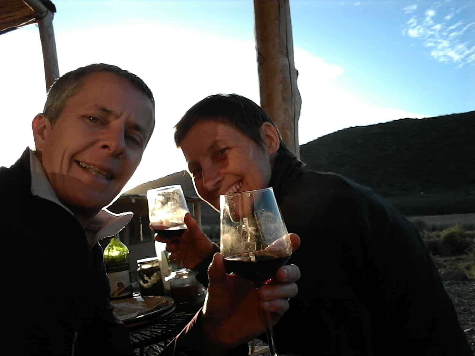 Ang and Sporty enjoying a glass of red wine with dinner, proving that living off grid doesn't mean forgoing creature comforts