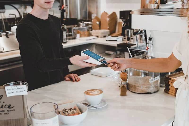 Person paying for a coffee with a credit card