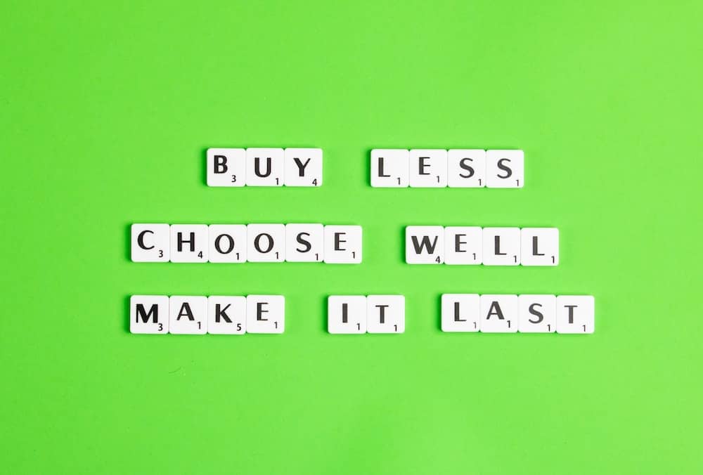 The words: buy less, choose well, make it last on a green background - fast fashion vs slow fashion